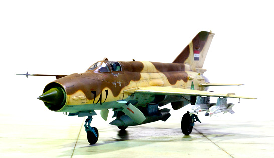 Front left view of Iraqi Air Force MiG-21MF in full weapons load model on white background.