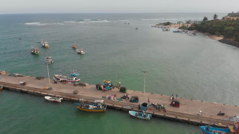 Aerial view of busy pier with fishing boats docked at day time, Sri Lanka