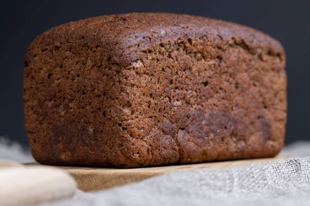 istock a square dark loaf of bread on the table 2099064171