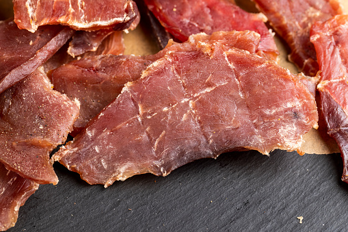 dried pork meat on the table in close-up, dried with salt and spices pork