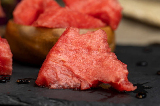 sliced into pieces of red ripe watermelon, the pulp of a ripe watermelon of red color lies on the table