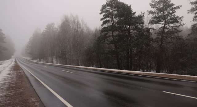 beautiful snow-covered road during fog in winter
