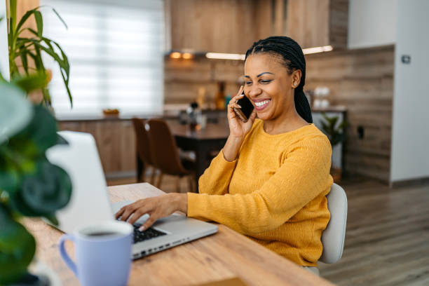 istock Young Woman Talking On The Phone While Working On A Laptop 2099068427