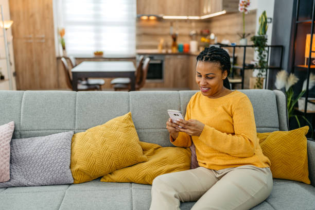 istock Young Woman Using Her Smart Phone On The Sofa At Home 2099070613