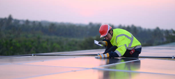 istock Male engineer works installing solar panels on the roof. Engineer or worker working on solar panels or photovoltaic cells on the roof of a business building. 2099075381