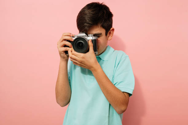 istock Teen boy with photo camera in the studio. 2099078516