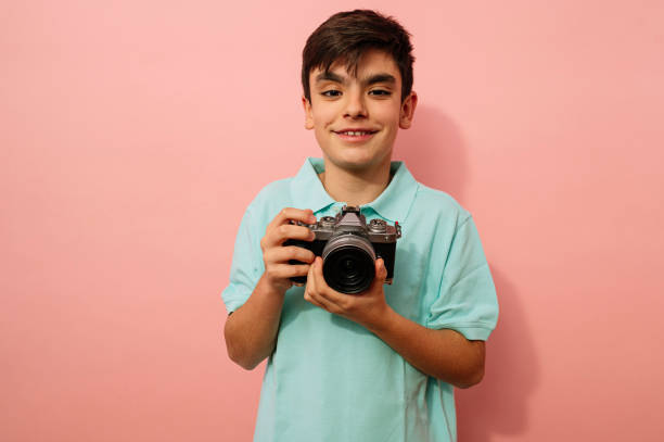 istock Teen boy with photo camera in the studio. 2099078528