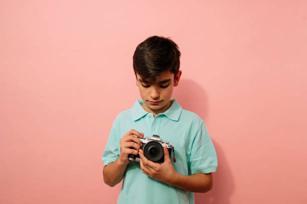istock Teen boy with photo camera in the studio. 2099078533