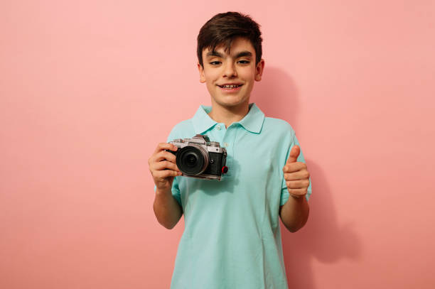 Teen boy with photo camera in the studio.