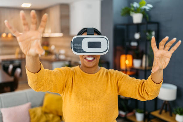 istock Young Woman Playing A Game On A Virtual Reality Headset At Home 2099080944