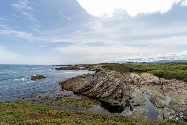 istock A rocky coastline with greenery under a partly cloudy sky, exuding natural beauty and tranquility. 2099087198