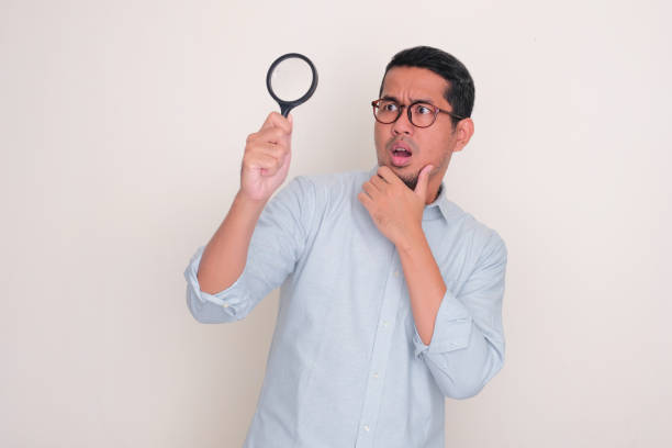 istock Adult man looking something using magnifying glass and showing shocked expression 2099095023
