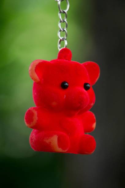 istock Red bear pendant on a key chain hanging against a green background 2099095206