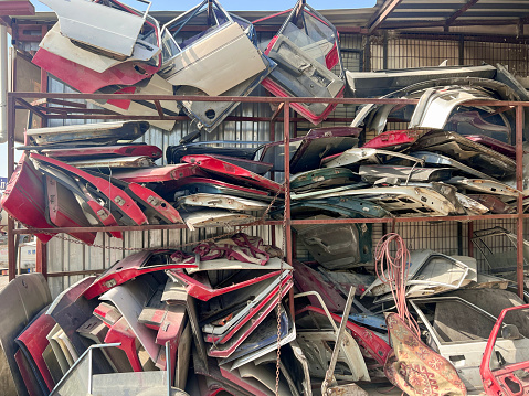 Scrapped, old but usable car parts are lined up in the junkyard.