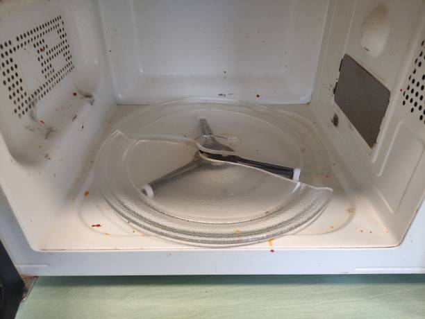 istock Old dirty microwave with a broken heat resistant glass dish 2099100280