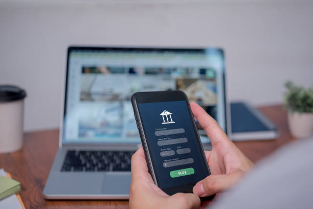 istock A person is using a cell phone to pay for something on a laptop 2099106715
