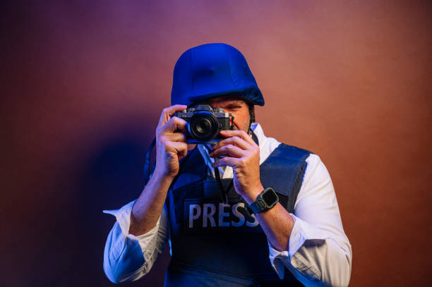 istock Reporter in bulletproof vest with a camera. 2099107828