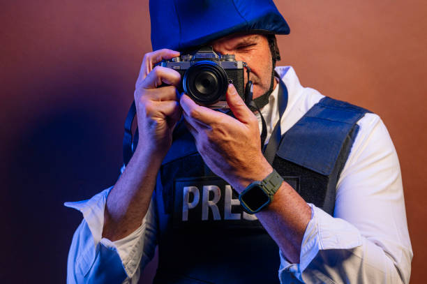 istock Reporter in bulletproof vest with a camera. 2099107837