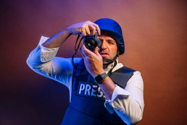 istock Reporter in bulletproof vest with a camera. 2099108371