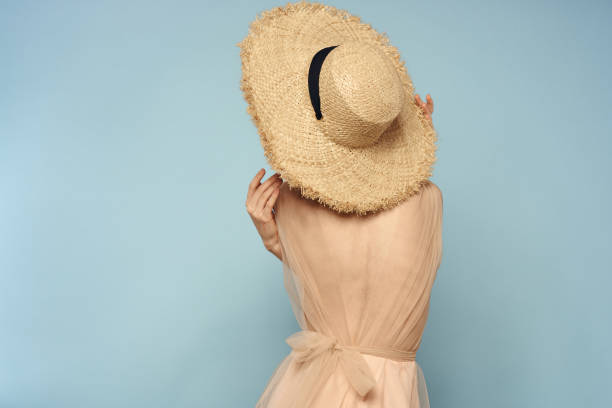 istock Woman in hat with naked back on blue background model back view 2099127491
