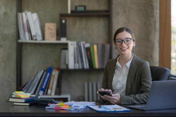 istock Happy businesswoman using a mobile phone while sitting in an office. 2099147129