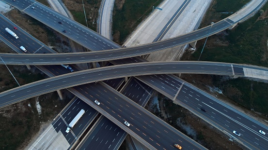 Engineering marvel: aerial view of multi-level interchange. Witness architectural prowess in action. Experience awe-inspiring beauty of this engineering marvel from above.Cinematic shot of freeway.