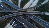 Engineering marvel: aerial view of multi-level interchange. Witness architectural prowess in action. Experience awe-inspiring beauty of this engineering marvel from above.Cinematic shot of freeway
