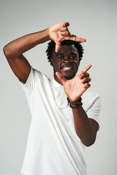 istock Smiling Young African Man Making a Frame With His Fingers in a Studio 2099162380