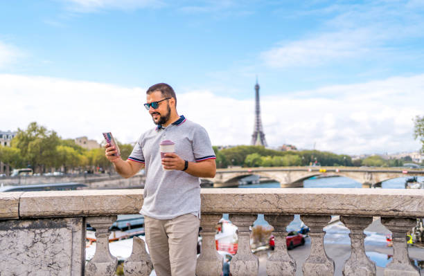 Young smiling man using phone in Paris, France