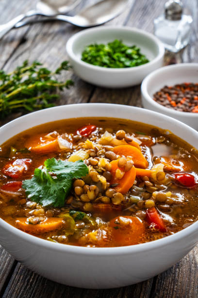istock Fresh vegetable soup with lentil on wooden table 2099170085