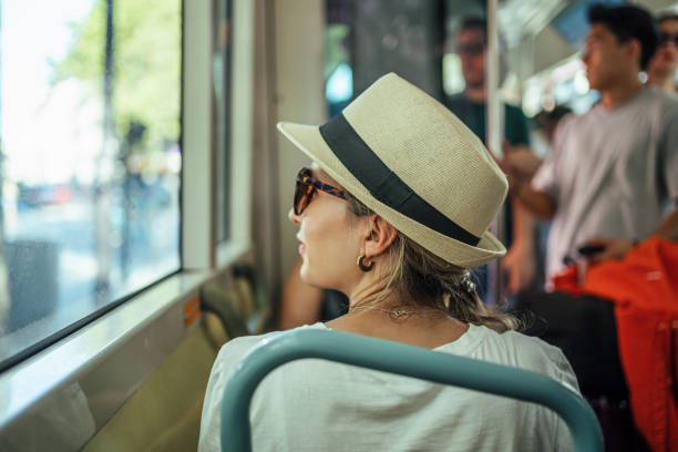 Young woman looks out the window while riding a city bus