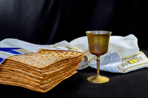 Jewish pesach attributes holiday with cup kosher wine, flatbread matzah at Passover