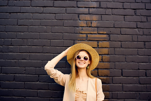 pretty woman outdoor walk fashion summer black brick wall . High quality photo