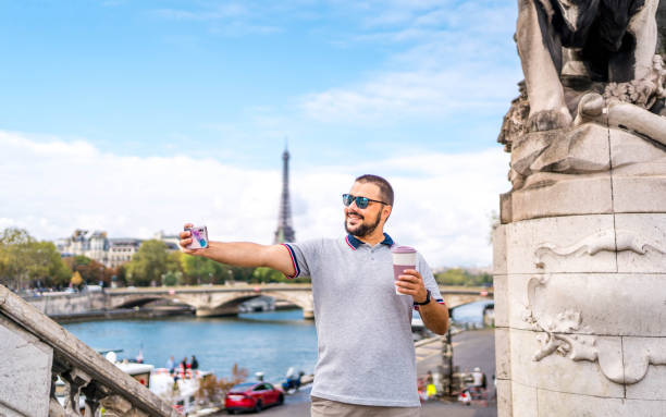 Young smiling man taking selfies in Paris, France