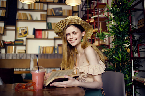 cheerful woman with a book in the hands of a cafe Lifestyle. High quality photo
