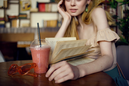 pretty woman reading a book in a cafe Lifestyle. High quality photo