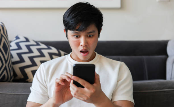 istock close up young asian man using smartphone with emotional surprise and excited feeling after become a winner on online lottery game monthly from website for lifestyle people concept 2099234078
