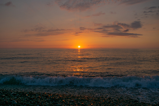 Beautiful sunset over the sea. Waves on the shore. Seascape. Marine background. Nature. Twilight.