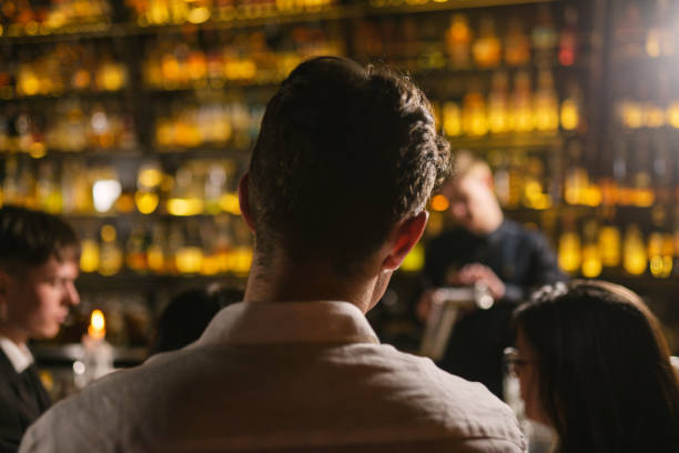 istock Brunette guy looks at bartender at fancy event in club 2099254339