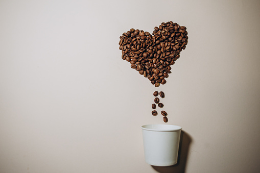 Roasted coffee beans in the shape of the heart.