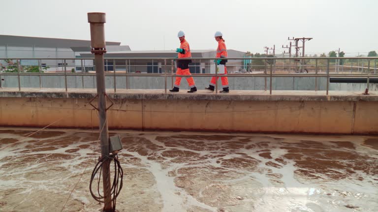 Two Water plant maintenance technicians work at wastewater treatment plants,Environmental engineers check the control system at the water treatment plant.