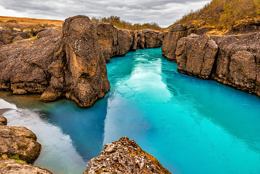 River with blue glacier water flows trough canyon in Iceland. Beautiful landscape