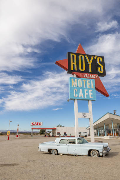 Roy's cafe and motel in Barstow 12/12/2023: Amboy, California, USA. Vintage neon sign of Roy's motel and cafe on Route 66 with vintage car. Sunny day. roadside motel stock pictures, royalty-free photos & images