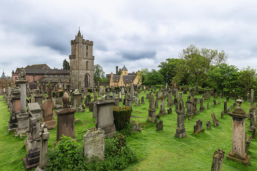Cemetery of the Holy Rude Church in Stirling, Scotland, its ancient gravestones dotting the lush greenery, evoking a sense of history and serenity