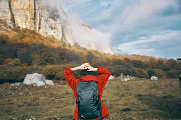 woman with a backpack red sweater warm hat landscape autumn fallen leaves model. High quality photo