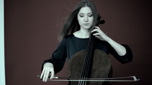 Musician playing cello. Cellist or Cello player performing with monochrome  background