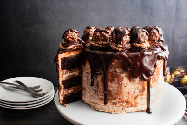istock Sliced Chocolate Cake Topped with Chocolate Ganache and Hazelnut Candies 2099301268