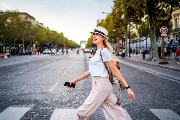 Young cheerful woman walking on Champs-Elysees Avenue in Paris, France