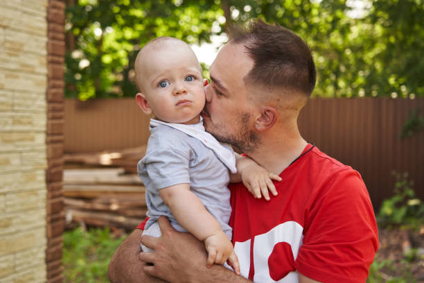 Dad sitting with his delighted one-year-old in a serene forest scene. High quality photo