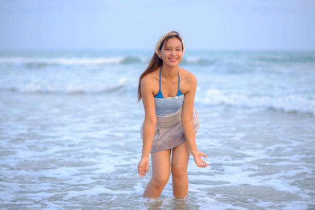 istock Asian model playing in the sea looking happy 2099332831